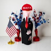 A man in a maga hat standing next to some red and blue stars.